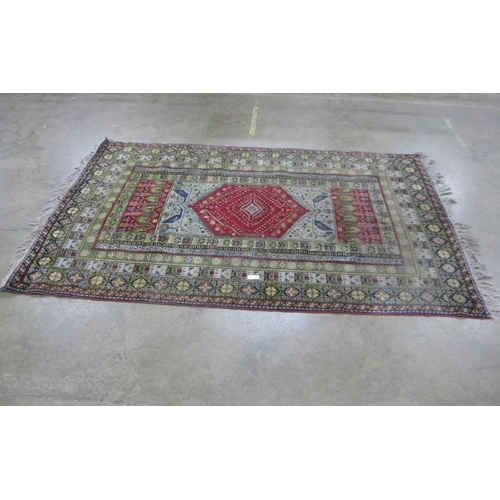 316 - Patterned rug on a red and green ground with tassels - 3m x 2.04m