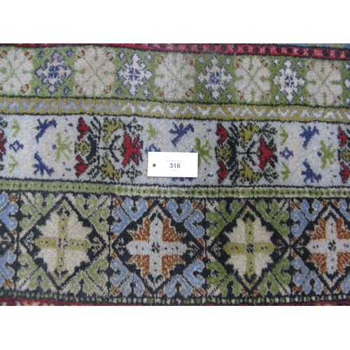 316 - Patterned rug on a red and green ground with tassels - 3m x 2.04m