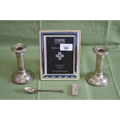 266 - Silver photograph frame, pair of silver candlesticks, silver tea spoon and a silver money clip