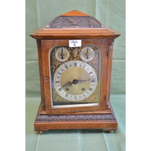 150A - Oak carved cased bracket clock with brass and silvered dial, black Roman Numerals and pierced black ... 