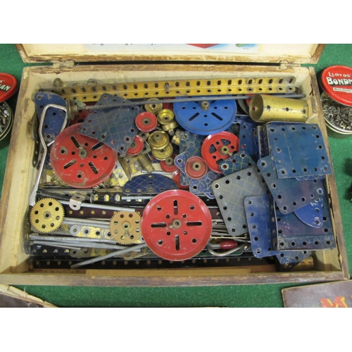 403 - Old wooden box of playworn blue, red and gold coloured Meccano with instructions for Outfits 1, 3 an... 