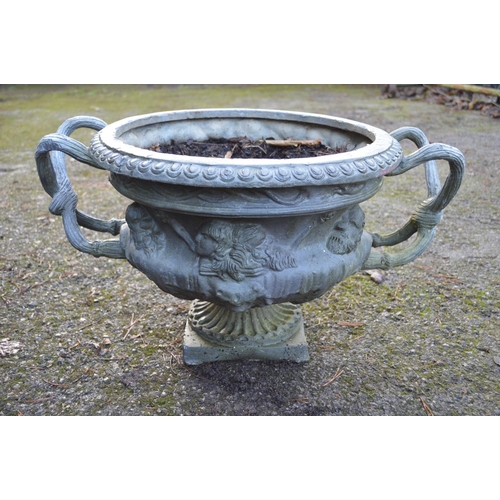 11 - Pair of 20th century lead garden urns the bowls decorated with faces and having root formed handles,... 