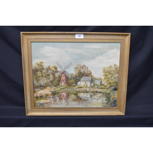 61 - MK Buck, oil on canvas of windmill and buildings at a waters edge, in unglazed gilt frame - 17