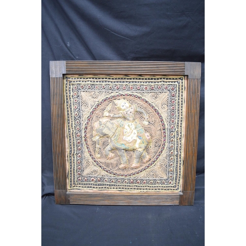 194 - Two Burmese tapestry wall hangings of figures on elephants, in unglazed wooden frames - 19.75