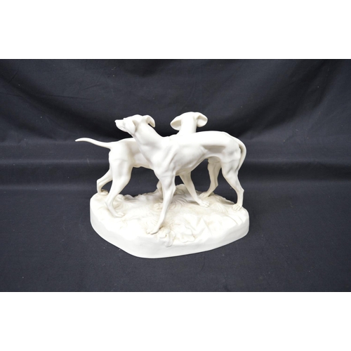 211 - Parianware figural group of two hounds standing on shaped base, impressed mark RC 179 - 8.25