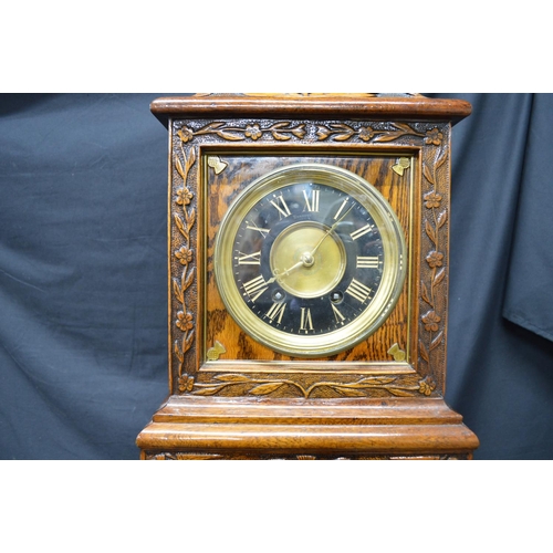 256 - Oak carved mantel clock by Bennett Bros. having black chapter ring with gilt Roman Numerals and gilt... 