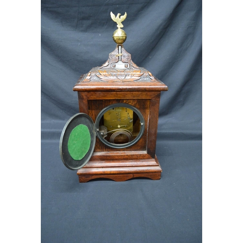 256 - Oak carved mantel clock by Bennett Bros. having black chapter ring with gilt Roman Numerals and gilt... 