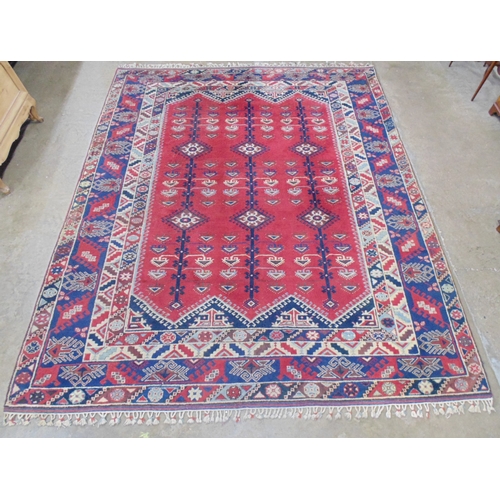 509 - Turkish patterned rug with red and blue ground having three geometric central motifs with a four sec... 