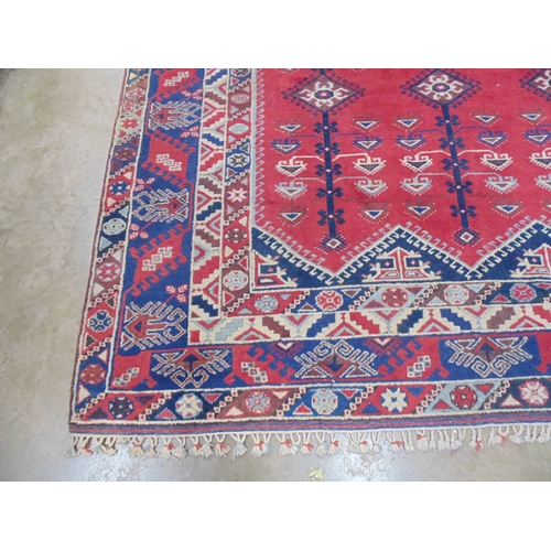 509 - Turkish patterned rug with red and blue ground having three geometric central motifs with a four sec... 