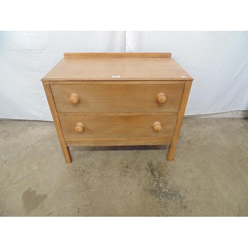 437 - Low oak chest of two long drawers with knob handles under a raised back, standing on square legs, CW... 