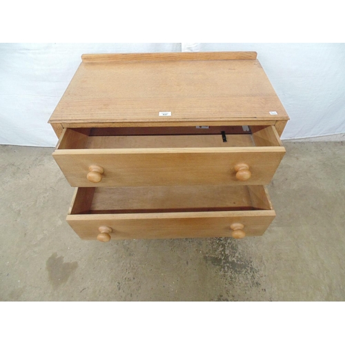 437 - Low oak chest of two long drawers with knob handles under a raised back, standing on square legs, CW... 