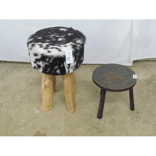 464 - A circular cow hide topped stool with four rustic wooden legs  - 30cm dia x 45cm tall together with ... 