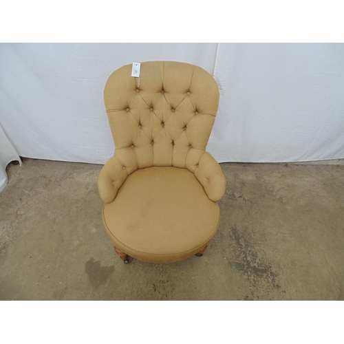 477 - Button back nursing chair having gold upholstery with turned legs (front) ending in castors - 59cm x... 