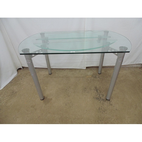 480 - Modern glass topped dining table having two glass swing out additional leaves, standing on four tubu... 