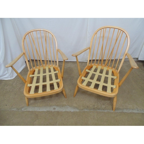 483 - Two blonde Ercol stick back open armchairs having webbing to base, standing on tapering legs and str... 