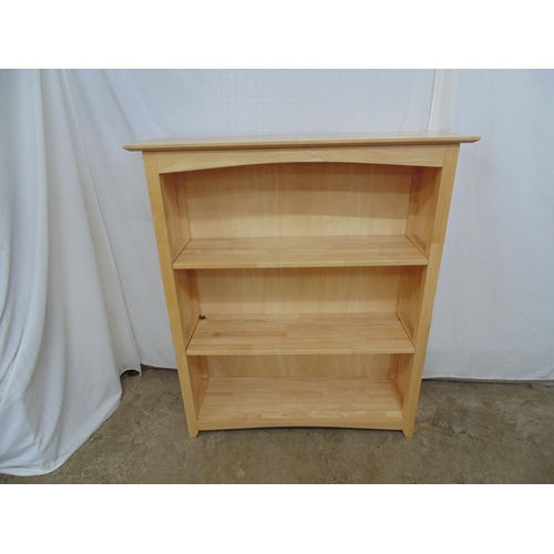 485 - Modern beech effect open bookcase having shaped frieze and two removable shelves, panelled sides and... 