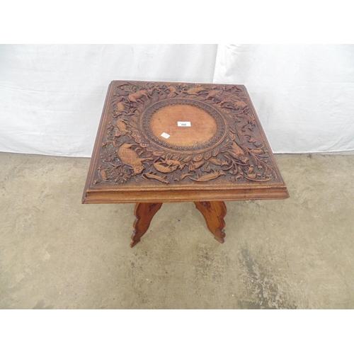 486 - Hardwood square topped occasional table having carving of animals and foliage, standing on a carved ... 