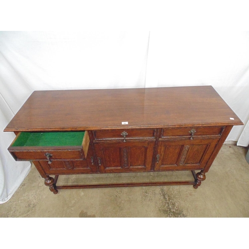 493 - Oak sideboard having three drawers (one baize lined) over three panelled cupboard doors, standing on... 