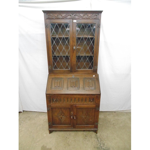 494 - Oak bureau bookcase the top having leaded light windows (one bowed) enclosing two shelves over linen... 