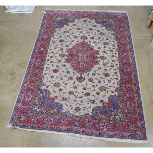 508 - Beige ground rug with central motif and red, blue, green and cream pattern with end tassels - 2.72m ... 