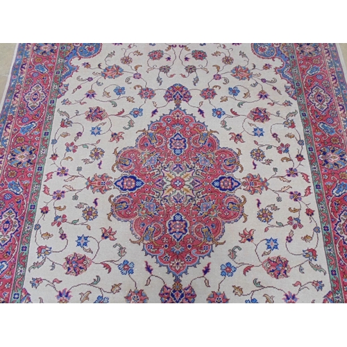 508 - Beige ground rug with central motif and red, blue, green and cream pattern with end tassels - 2.72m ... 