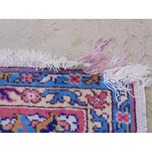 508 - Beige ground rug with central motif and red, blue, green and cream pattern with end tassels - 2.72m ... 