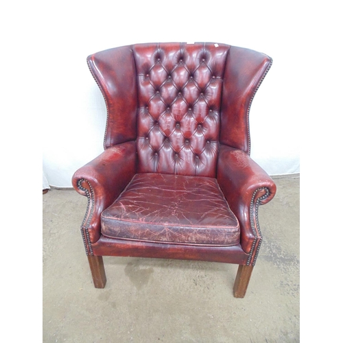 511 - Red leather wing back armchair having buttoned back and studwork, standing on square legs - 84cm x 7... 