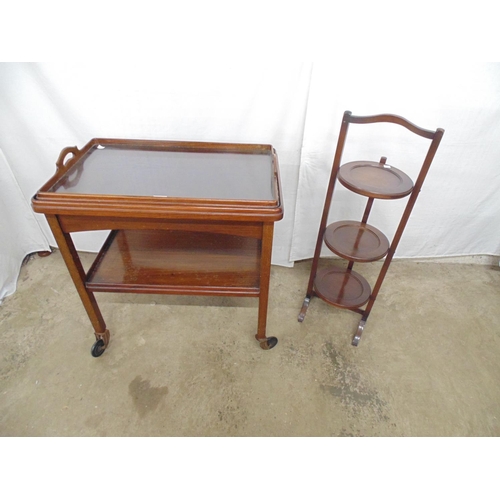 516 - Mahogany and walnut two tier tea trolley having a lift out glass bottom two handled tray, standing o... 