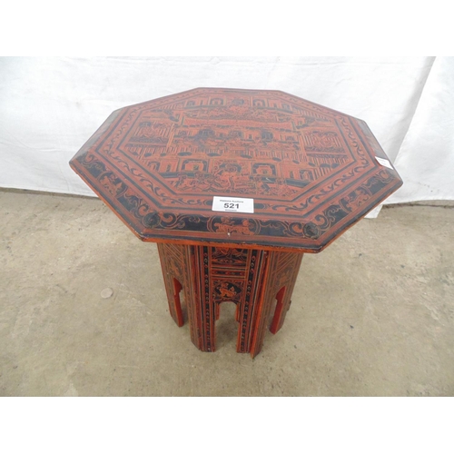 521 - Small Oriental octagonal lacquered folding occasional table the top being decorated with figures sur... 