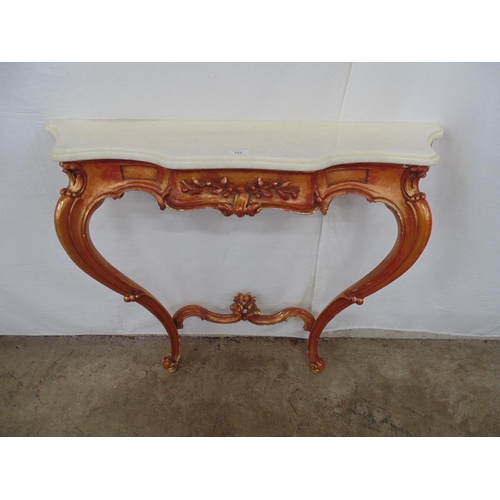 542 - White marble topped serpentine fronted console table having a rose gilt carved base with floral deco... 