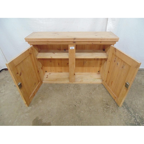 543 - Pine wall cabinet the two panelled doors opening to a single fixed shelf - 81cm x 23cm x 54cm tall