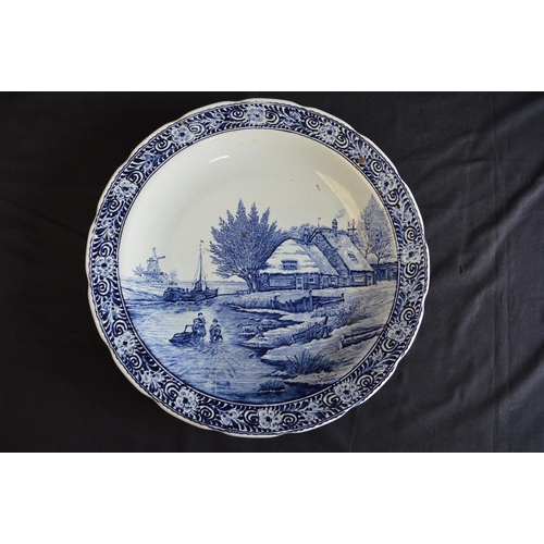 189 - Two Delft blue and white wall hanging chargers decorated with scenes of children playing on a frozen... 