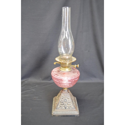 236 - Group of three iron based oil lamps each having glass reservoir and chimney - tallest 57.5cm