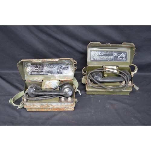 54 - Two British Army field telephones each numbered YA 7815 with broad arrow and having woven shoulder s... 