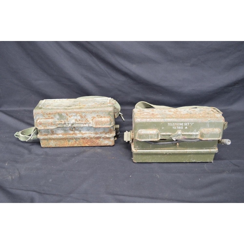 54 - Two British Army field telephones each numbered YA 7815 with broad arrow and having woven shoulder s... 