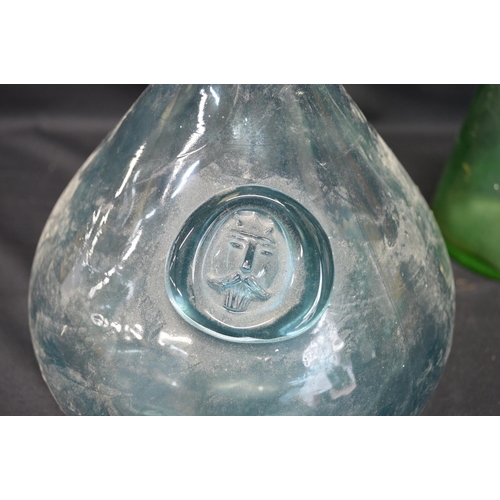 56 - Pale blue Holmgaard glass carafe with Viking face seal - 22cm tall together with a green glass caraf... 