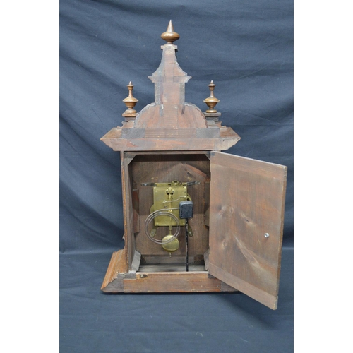 63 - Walnut cased mantle clock of architectural style having brass face with silvered chapter ring, black... 