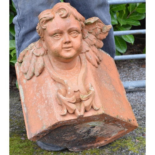 148 - Terracotta corner stone in the form of a cherubs head - 43cm x 35cm tall