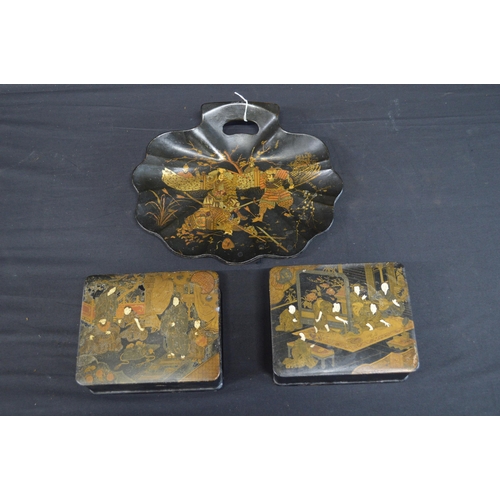 229 - Pair of lacquered papier mache boxes with hinged lids decorated with scenes of figures - 18cm wide t... 