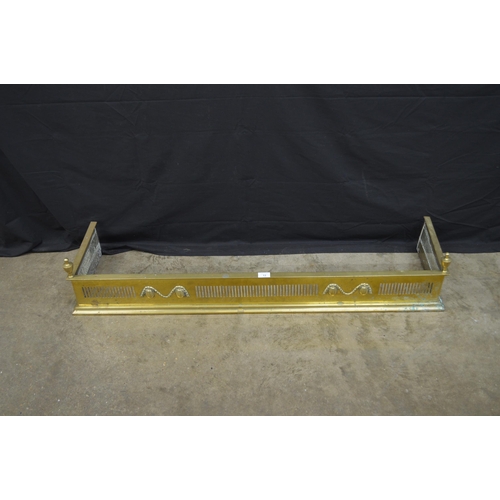 13 - Brass fire fender with pierced front and sides, with urn formed finials - 126cm wide