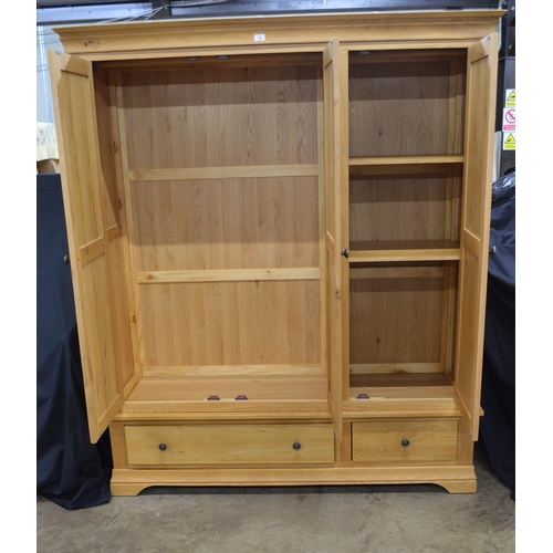 289 - Modern oak triple wardrobe, the top section having three panelled doors, two doors opening to a hang... 