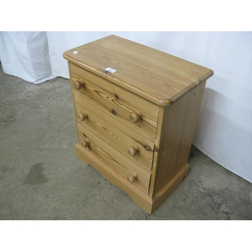 315 - Small pine chest of three drawers, standing on a shaped plinth base - 53cm x 29.5cm x 61cm tall