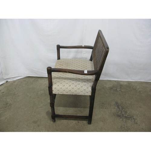 333 - Mahogany open elbow chair having a cane panel back and padded seat, standing on turned front legs wi... 