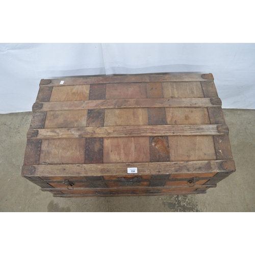 334 - Wooden metal bound dome top trunk, the hinged lift top lid opening to a canvas lined interior, stand... 