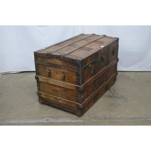 334 - Wooden metal bound dome top trunk, the hinged lift top lid opening to a canvas lined interior, stand... 