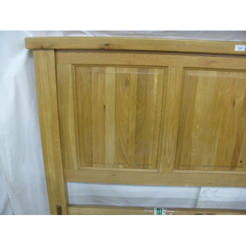 335 - Modern oak bed, the headboard having a panelled back with a wood slatted base (fourteen slats and a ... 