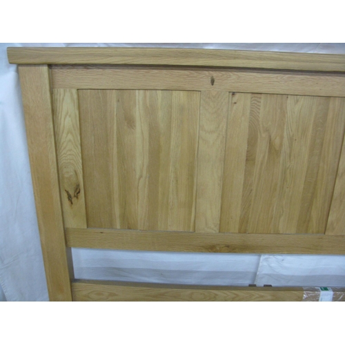 335 - Modern oak bed, the headboard having a panelled back with a wood slatted base (fourteen slats and a ... 