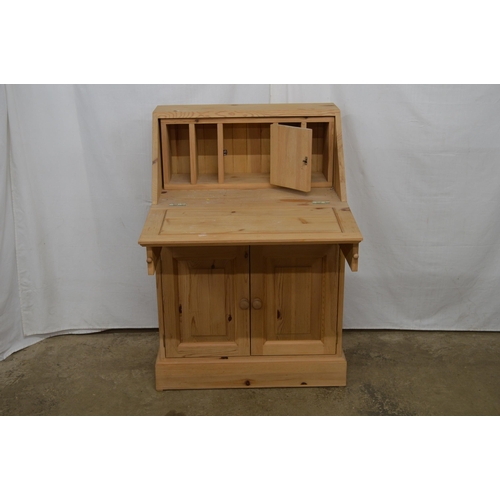 340 - Pine bureau having a fall front opening to a small central cupboard blanked by pigeon holes over a s... 