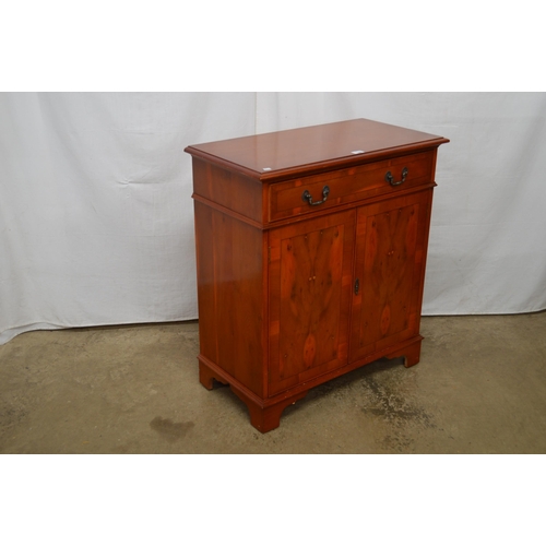 344 - Reproduction yew wood inlaid cross banded side cabinet having a single drawer over two doors opening... 