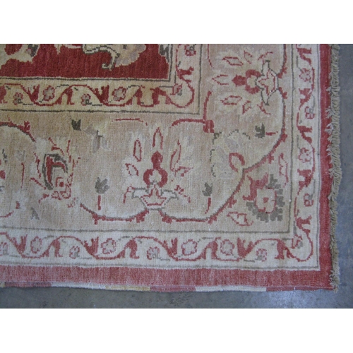 351 - Large red and pale orange ground patterned rug having a large central design surrounded by patterned... 